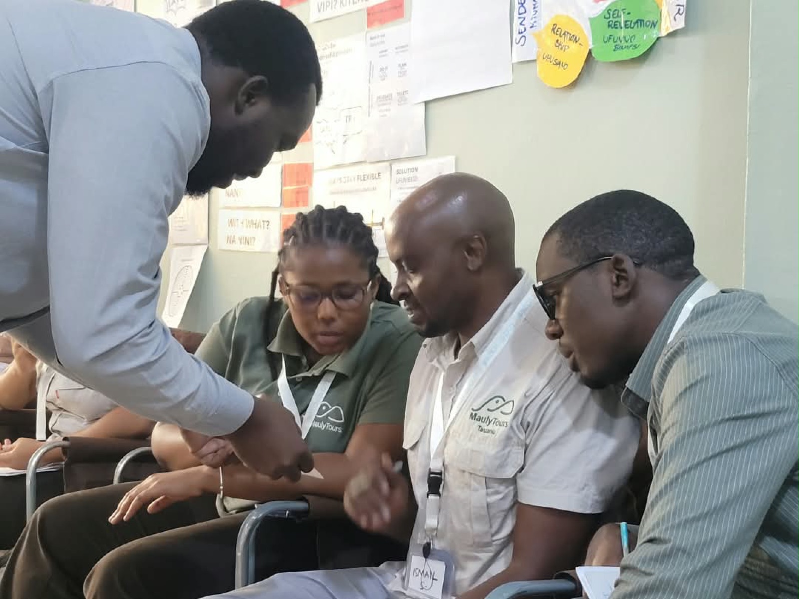 A WATCHOUT facilitator works hands-on with seated participants